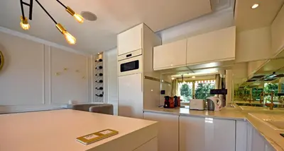a kitchen with white cabinets and a counter top at Piscine privée, Plages à pied & Palais à proximité in Cannes