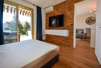 a bedroom with a large bed and a brick wall at Piscine privée, Plages à pied & Palais à proximité in Cannes