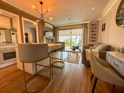 a kitchen and living room with a table and a couch at Piscine privée, Plages à pied & Palais à proximité in Cannes