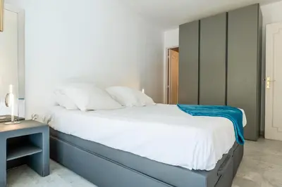 a bedroom with a blue and white bed and a table at 2-Room Apartment with Terrace Sea View in Cannes