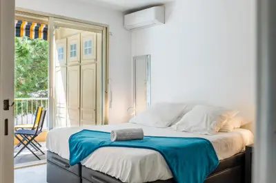 a bedroom with a bed with a blue blanket on it at 2-Room Apartment with Terrace Sea View in Cannes