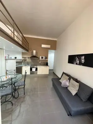 a living room with a couch and a glass table at Charmant studio centre ville Cannes in Cannes
