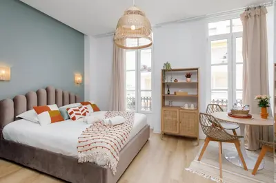 a bedroom with a bed and a table with a chair at Confortable studio Cannes centre in Cannes
