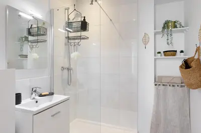 a white bathroom with a shower and a sink at Confortable studio Cannes centre in Cannes
