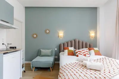 a bedroom with two beds and a blue chair at Confortable studio Cannes centre in Cannes