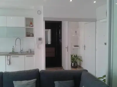 a living room with a couch and a kitchen at Appartement Les Eucalyptus dans domaine privé à Cannes in Cannes