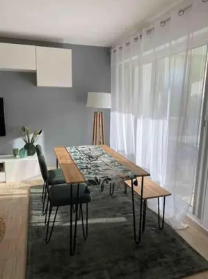 a dining room table and chairs in a room at Appartement Les Eucalyptus dans domaine privé à Cannes in Cannes