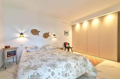 a bedroom with a large bed and a desk at Appartement Reina Pointe Croisette Palm Beach in Cannes