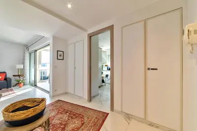 a living room with white walls and a large glass door at Appartement Reina Pointe Croisette Palm Beach in Cannes