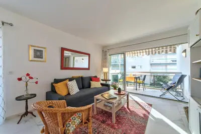 a living room with a couch and a table at Appartement Reina Pointe Croisette Palm Beach in Cannes