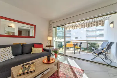 a living room with a couch and a table at Appartement Reina Pointe Croisette Palm Beach in Cannes