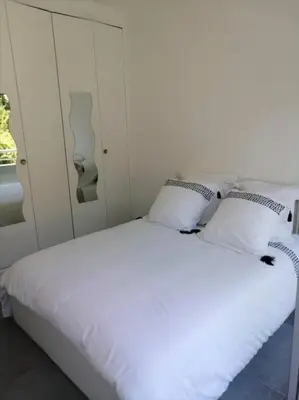 a white bed with two pillows in a bedroom at L'Orangeraie Centre Cannes Martinez, Beau F2 avec terrasse in Cannes