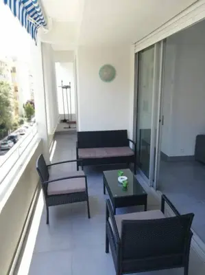 a balcony with chairs and tables on a building at L'Orangeraie Centre Cannes Martinez, Beau F2 avec terrasse in Cannes