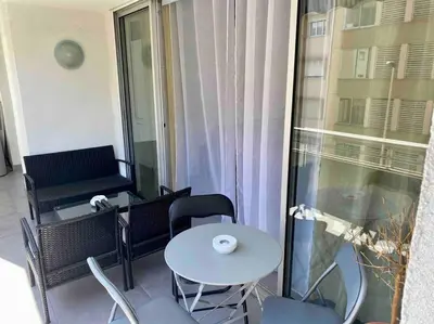 a balcony with a table and chairs and a window at L'Orangeraie Centre Cannes Martinez, Beau F2 avec terrasse in Cannes