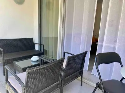 a living room with a couch and a table and chairs at L'Orangeraie Centre Cannes Martinez, Beau F2 avec terrasse in Cannes