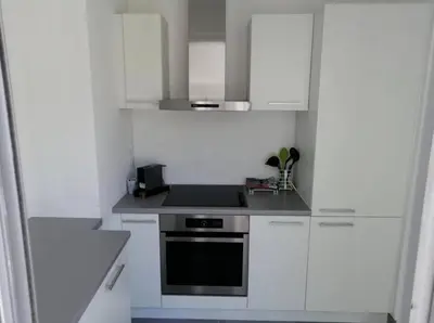 a kitchen with white cabinets and a stove at L'Orangeraie Centre Cannes Martinez, Beau F2 avec terrasse in Cannes