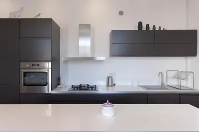 a kitchen with black cabinets and a white counter top at Carnot Prestige – Spacious & Central in Cannes
