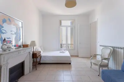 a white room with a bed and a fireplace at Carnot Prestige – Spacious & Central in Cannes