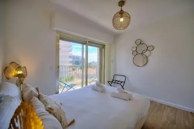a bedroom with a bed and a large window at IMMOGROOM - 5 min from the Croisette beaches - Terrace - Ac - Sea view in Cannes