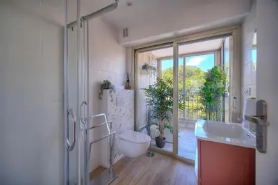 a bathroom with a toilet and a sink and a window at IMMOGROOM - 5 min from the Croisette beaches - Terrace - Ac - Sea view in Cannes