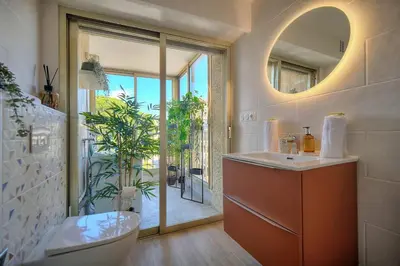 a bathroom with a toilet and a sink and a mirror at IMMOGROOM - 5 min from the Croisette beaches - Terrace - Ac - Sea view in Cannes