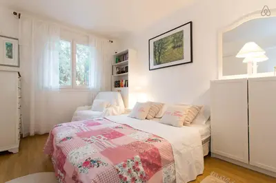 a white bedroom with a bed and a chair at Holiday or Congress, Centre - Beach in Cannes