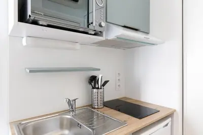 a kitchen with a sink and a microwave at Comfortable studio W balcony Cannes center TGV in Cannes