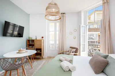 a living room with a couch and a table at Comfortable studio W balcony Cannes center TGV in Cannes