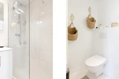 a white bathroom with a shower and a toilet at Comfortable studio W balcony Cannes center TGV in Cannes