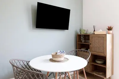 a white table and chairs in a room with a tv at Comfortable studio W balcony Cannes center TGV in Cannes
