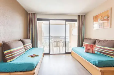a room with two beds and a balcony at Résidence La Palme d'Azur Cannes Verrerie in Cannes