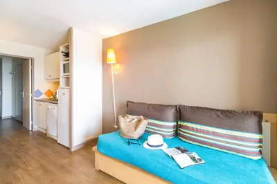 a room with a couch and a table with a book at Résidence La Palme d'Azur Cannes Verrerie in Cannes