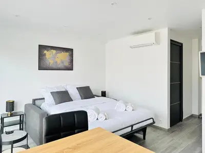 a white bed in a room with a table at Le Royal Carnot - Studio - Cannes Centre Terrasse in Cannes