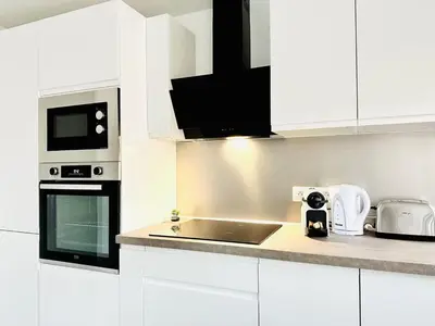 a white kitchen with a sink and a microwave at Le Royal Carnot - Studio - Cannes Centre Terrasse in Cannes