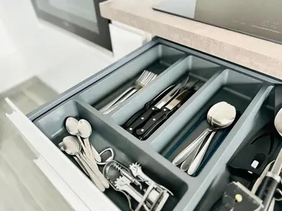 a drawer filled with silver utensils in a kitchen at Le Royal Carnot - Studio - Cannes Centre Terrasse in Cannes