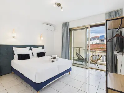 a bedroom with a large bed and a balcony at Central -300m Palais- Seaview-A/C-WIFI-spacieux in Cannes