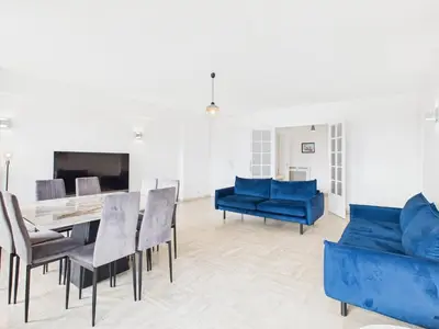 a living room with blue furniture and a table and chairs at Central -300m Palais- Seaview-A/C-WIFI-spacieux in Cannes