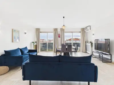 a living room with two blue couches and a television at Central -300m Palais- Seaview-A/C-WIFI-spacieux in Cannes