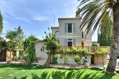 a house with a palm tree in the yard at Villa vue mer Cannes in Mougins