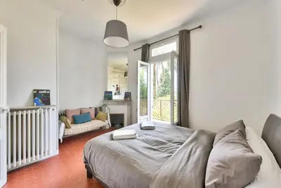 a bedroom with a bed and a couch and a window at Villa vue mer Cannes in Mougins