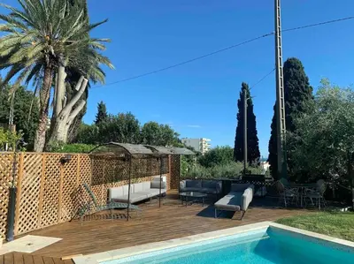 a patio with a couch and chairs next to a pool at Villa vue mer Cannes in Mougins