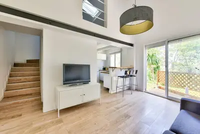 a living room with a television and a staircase at Villa vue mer Cannes in Mougins