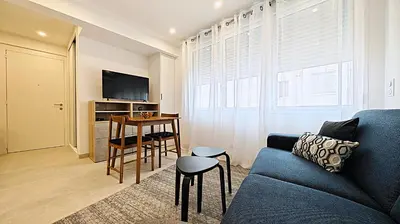 a living room with a blue couch and a table at Viva Riviera Brand New Top Floor close Croisette in Cannes