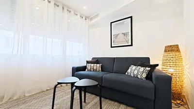 a living room with a couch and two stools at Viva Riviera Brand New Top Floor close Croisette in Cannes
