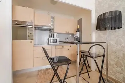a kitchen with a table and chairs in a room at Studio charmant au cœur de Cannes avec balcon et parking in Cannes