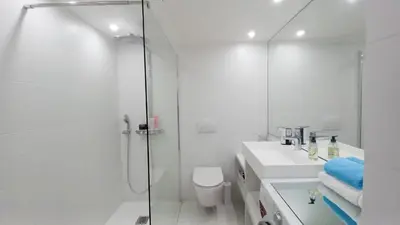 a white bathroom with a shower and a toilet at Bella Park in Cannes