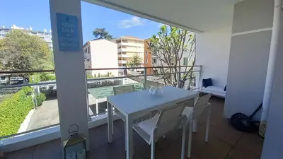 a white table and chairs in a room with a balcony at Bella Park in Cannes