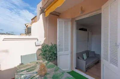 a balcony with a bed and a couch on a patio at Un Écrin au Suquet - Studio, clim, balcon, plage, Palais des Festivals in Cannes