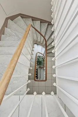 a staircase with a mirror in a room with white marble at Cozy 1 bedroom flat,free parking, close to center in Cannes