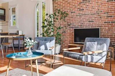 two chairs and a table in a living room with a brick wall at Cozy 1 bedroom flat,free parking, close to center in Cannes